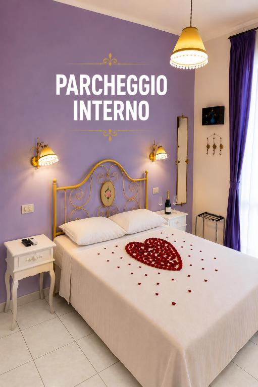 a bedroom with a large bed with a red flower on it at Il Melangolo in SantʼAntìoco