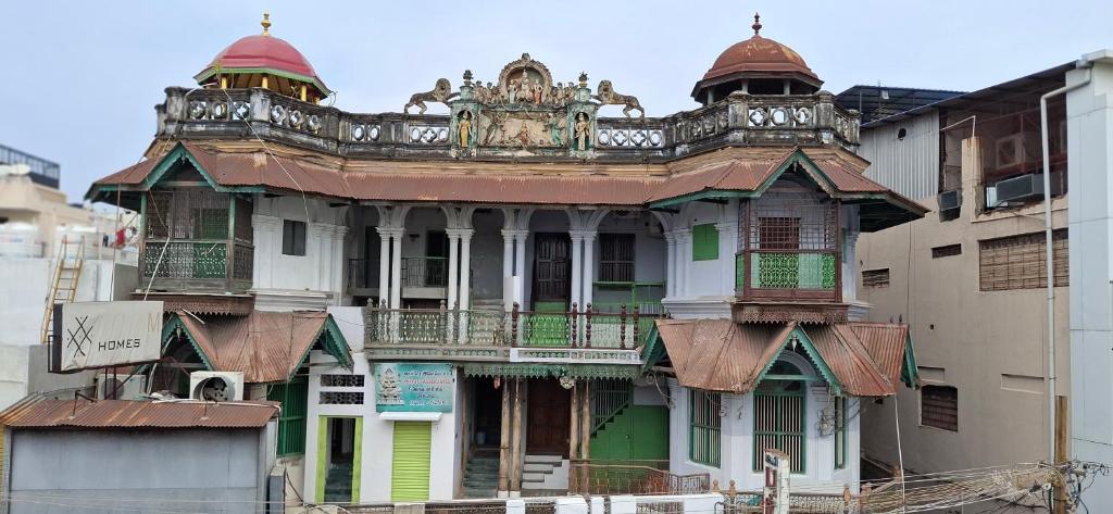 an old building with a building with a turret at Umbrella Guest House - Palace Suite in Madurai