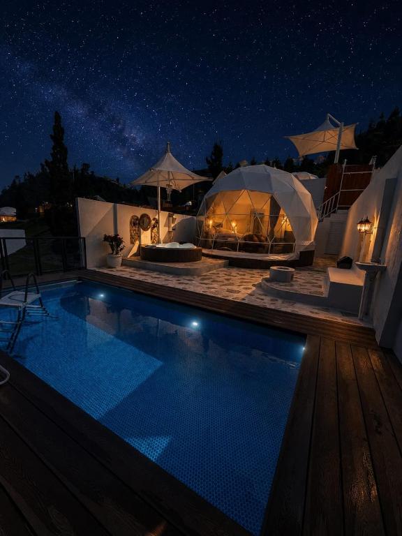 a swimming pool at night with a tent at Glamping Grand Mazaya Private Pool in Bandung