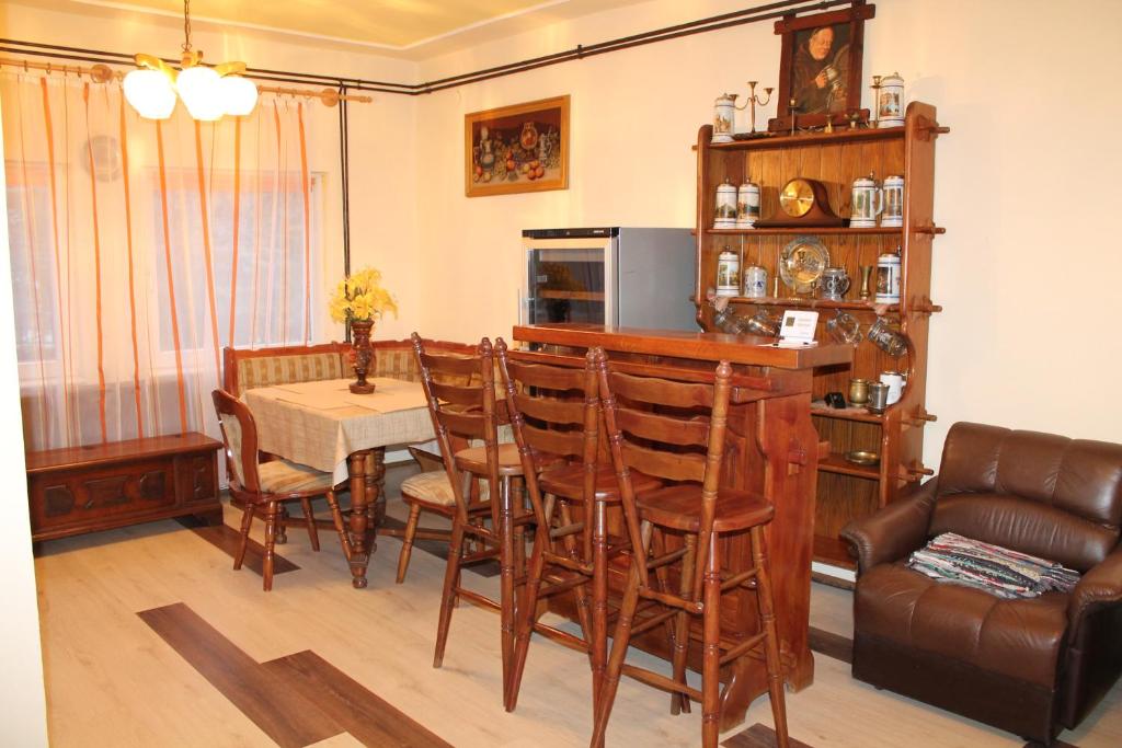 uma sala de estar com uma mesa e cadeiras e um sofá em Ruttkai Vendégház em Székesfehérvár