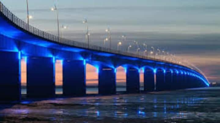 a blue bridge over the water with a sunset at Apt cosy dans maison de charme in La Rochelle
