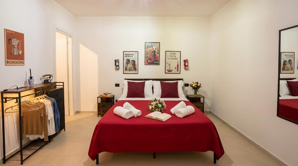 a bedroom with a red bed with two pillows at VaSaMi - Appartamento in centro in Bari