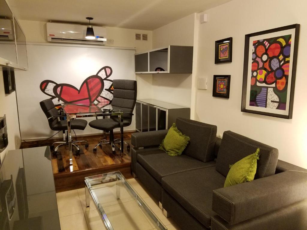 una sala de estar con sofá y una pintura al corazón en la pared en Departamento Alta Gracia en Alta Gracia