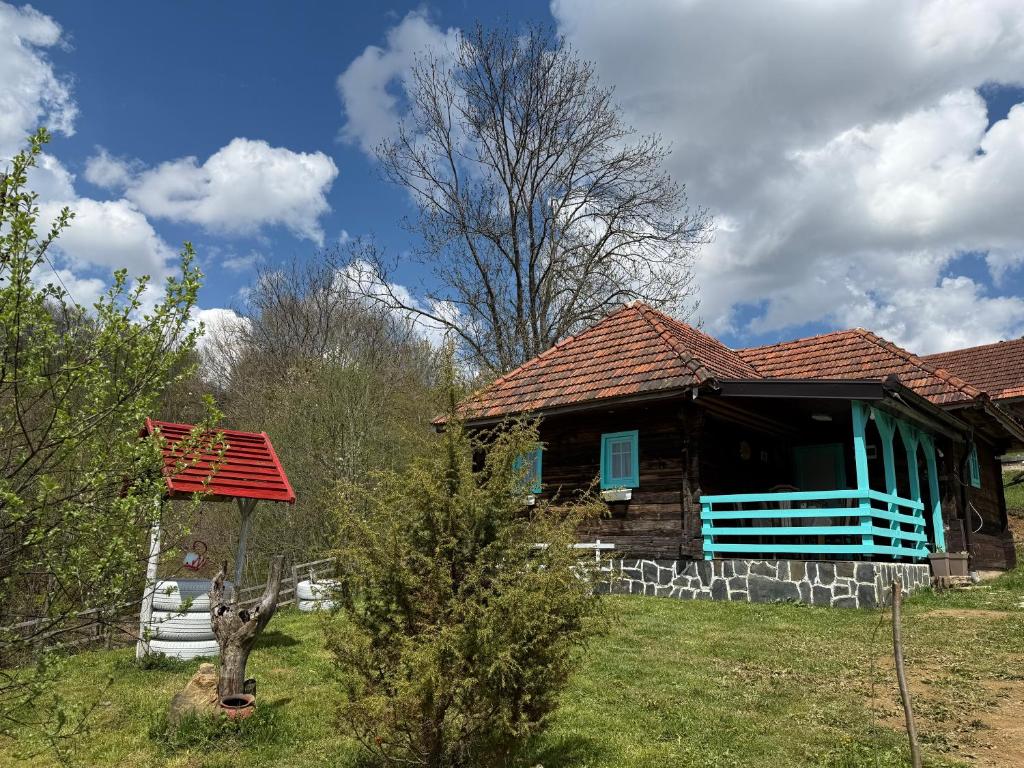 a house with a red roof and a blue window at Etno selo Raković in Ivanjica