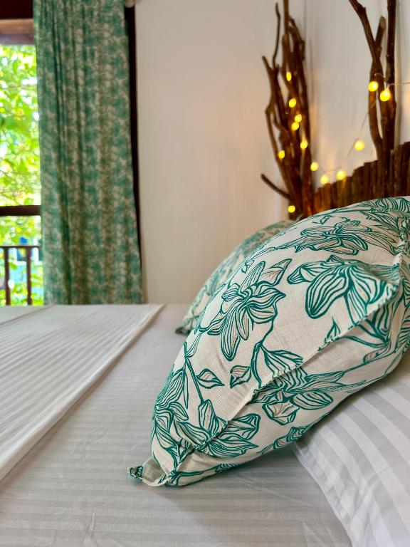 a pillow sitting on top of a bed at Papaya Hikkaduwa in Hikkaduwa