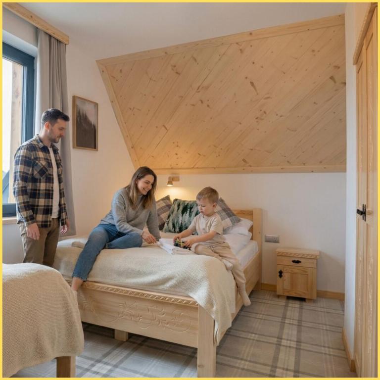 a woman and a child sitting on a bed at Domki Tomanova - Premium Chalets in Dzianisz
