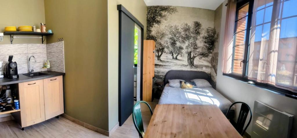 a room with a table and a kitchen with a sink at Moustier in Montauban