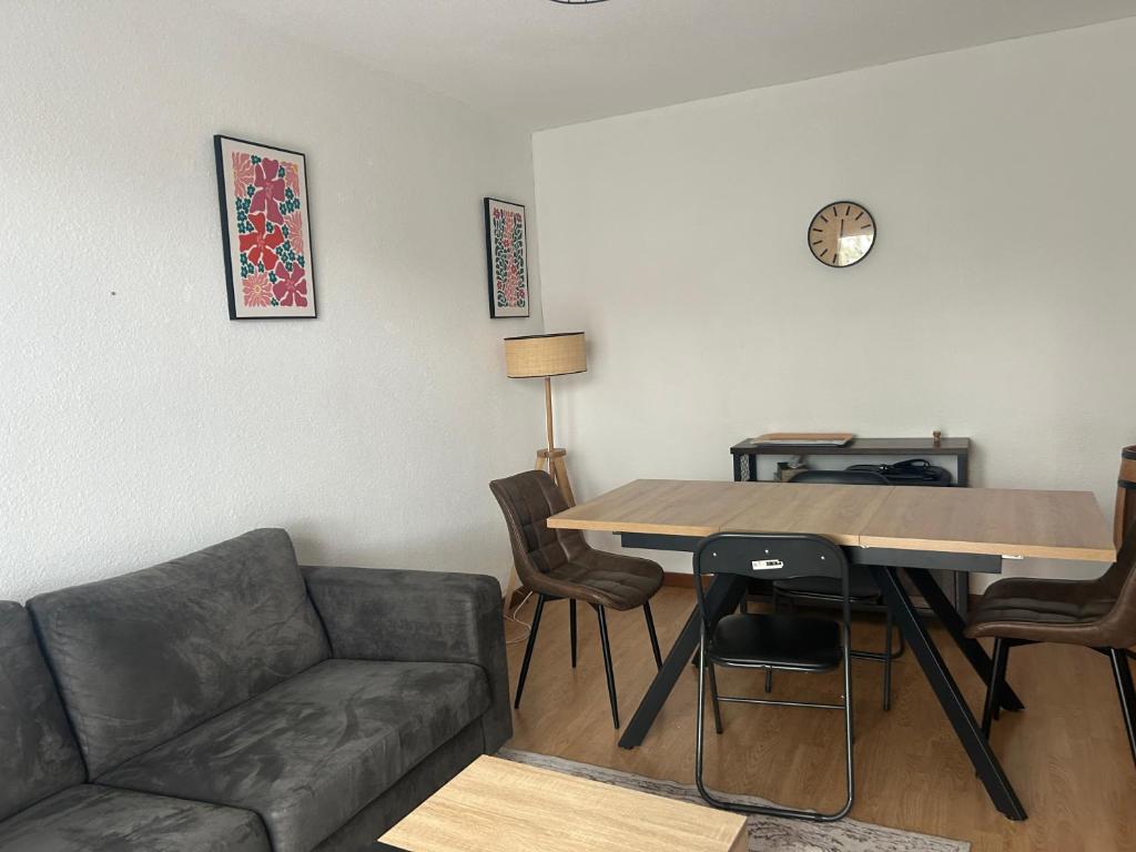 a living room with a couch and a table at Le cocon du télésiège - Piscine chauffée - Métabief in Métabief