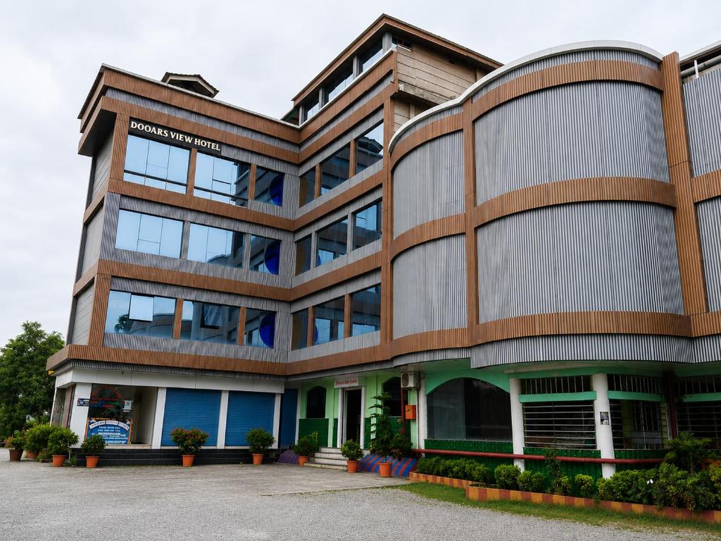 a large office building with a lot of windows at Dooars View Hotel in Hāsimāra