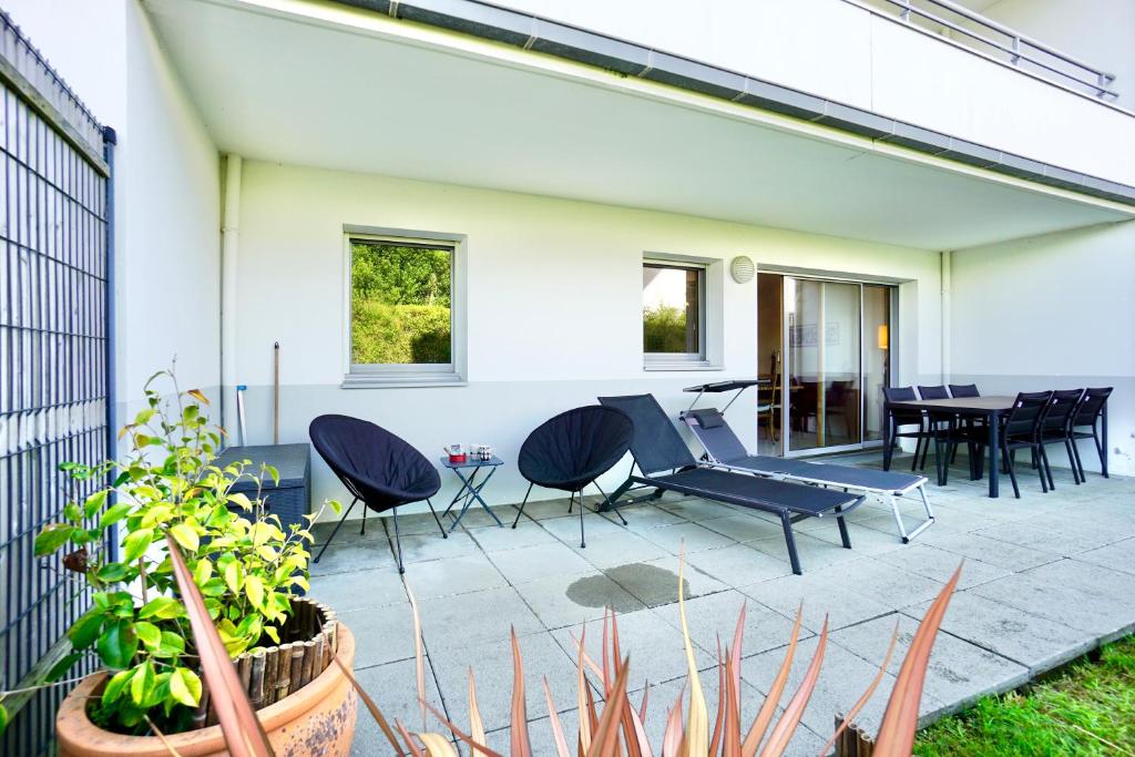 a patio with chairs and a table and a dining room at L'Amirage * à 200m de la mer* in Ploemeur