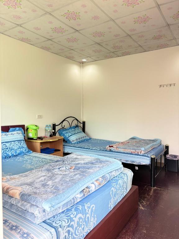 two beds in a room with a ceiling at บ้านพักสมพงศ์ภูทับเบิก in Ban Maeo Thap Boek