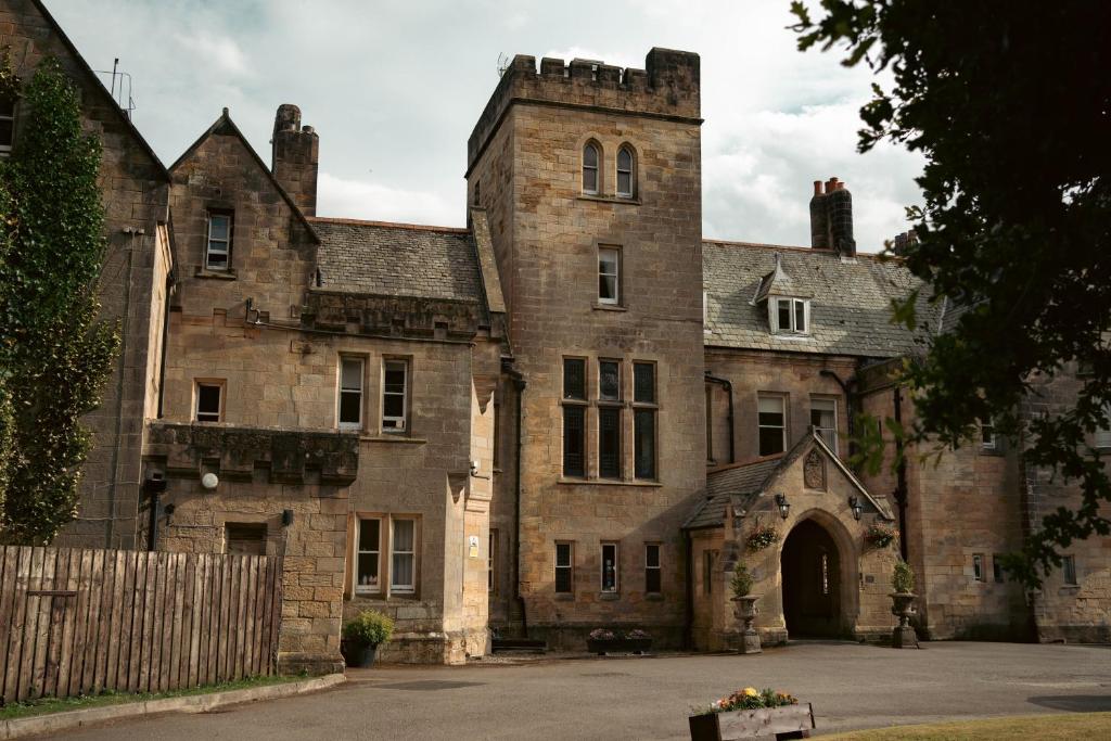 an old stone building with a gate in front of it at Grinkle Park Hotel in Loftus