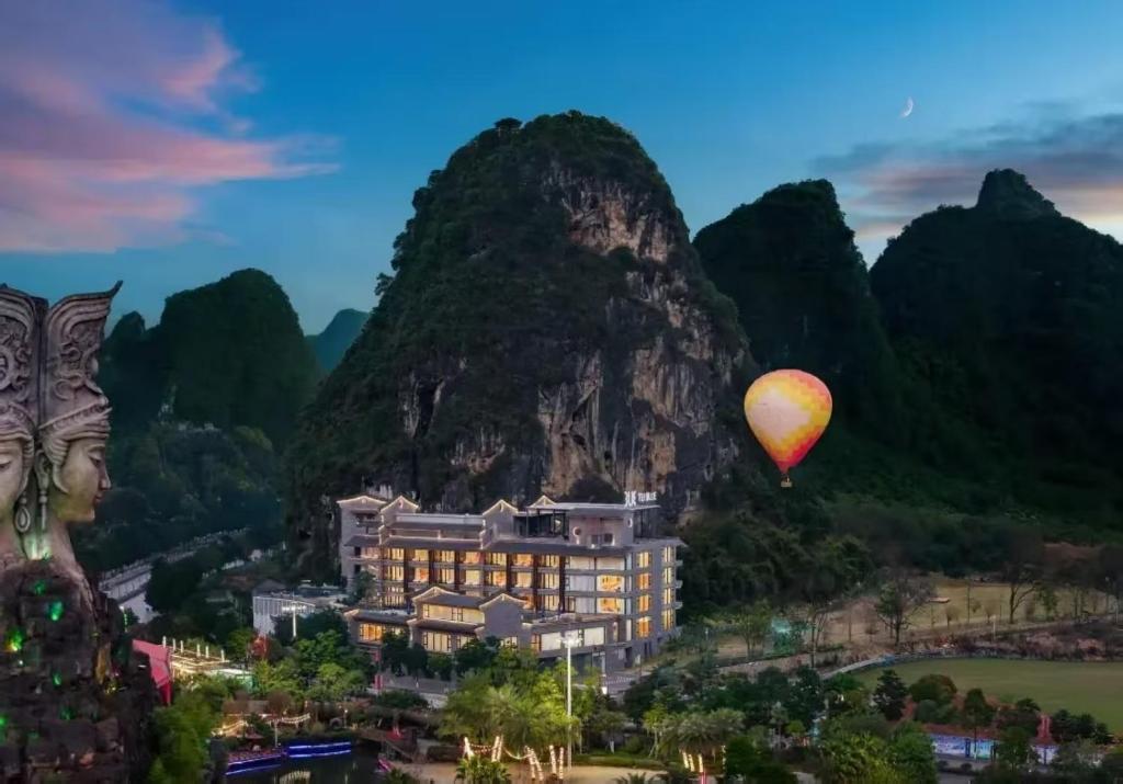 a hot air balloon flying over a resort in the mountains at TUI Blue Yangshuo Xiangheli Hotel in Yangshuo