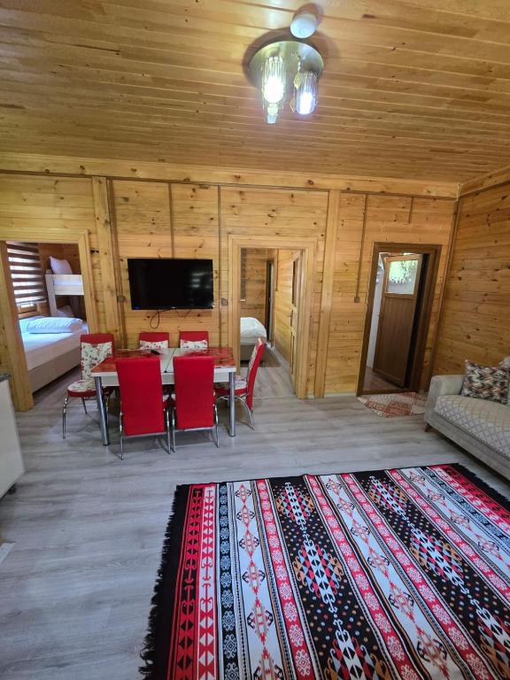 a living room with a couch and a table with red chairs at Katipogulları Apart in Uzungöl