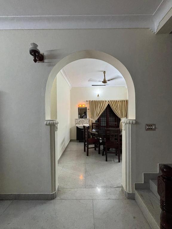 an archway leading into a dining room with a table at Stay at Renovated Home at DBRA-61 Don Bosco Cross Road Vaduthala Ernakulam in Cochin