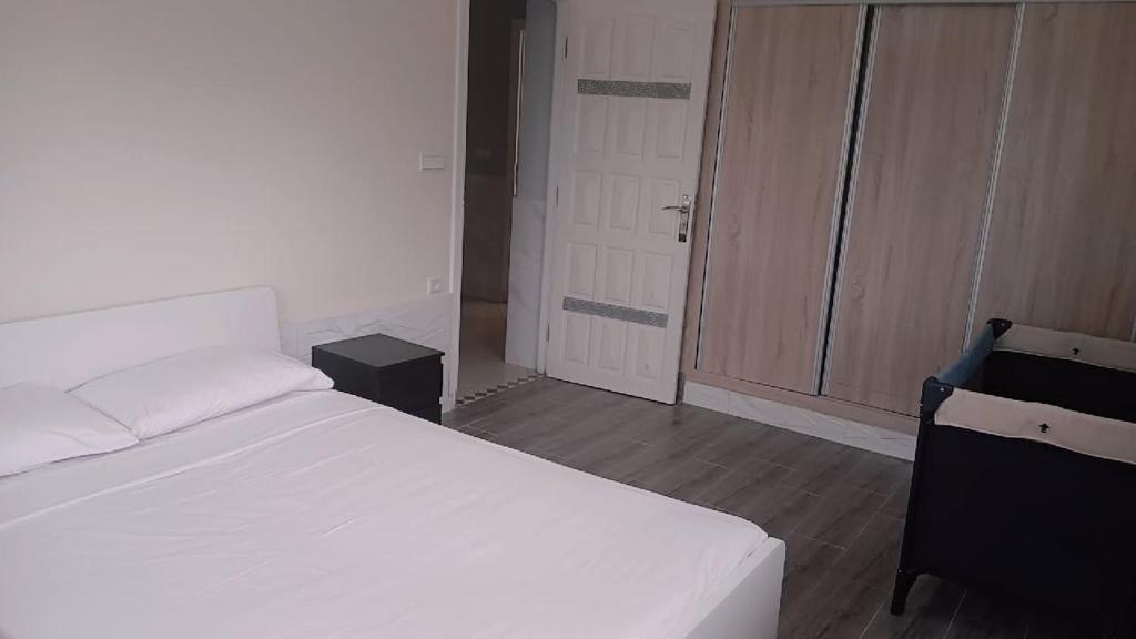a bedroom with a white bed and a door at Palm Serenity in Tangier