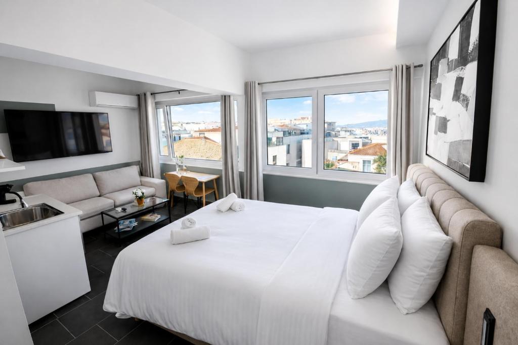 a hotel room with a white bed and a couch at The Athenian Pearl in Athens
