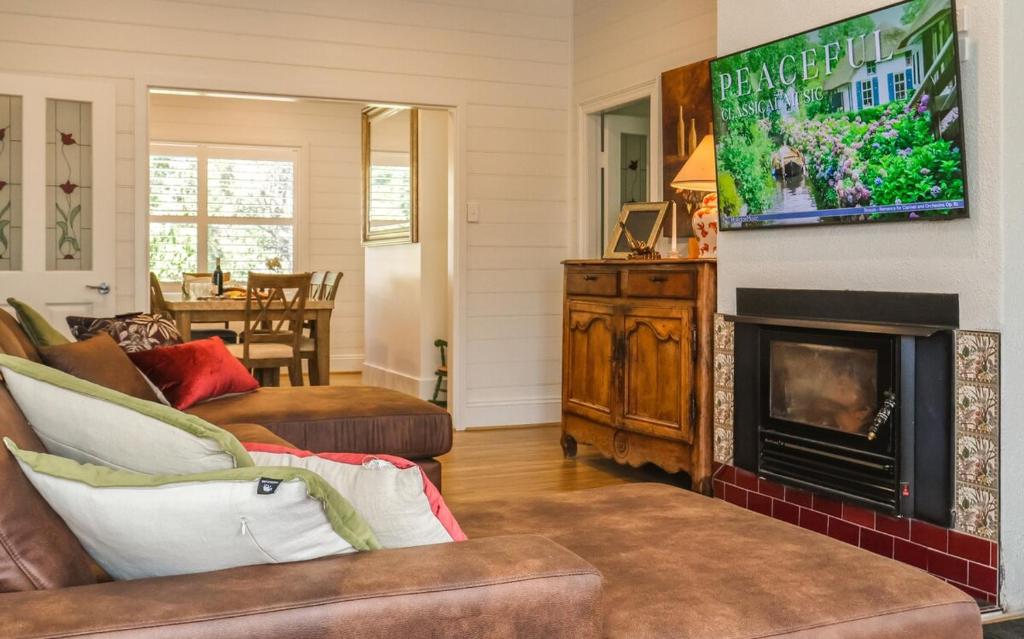 a living room with a couch and a fireplace at Handleys Cottage in High Range