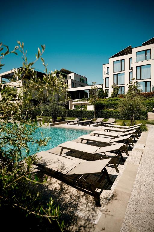 a row of lounge chairs next to a swimming pool at THERMA NUMERA Mineral SPA & Longevity in Burgas