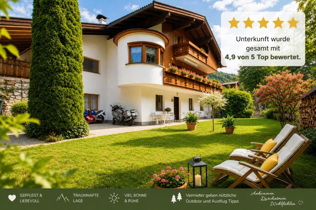 a house with a lawn with chairs in front of it at Ferienwohnung in Itter bei Söll SkiWelt Wilder Kaiser Kitzbüheler Alpen ITD100 in Itter