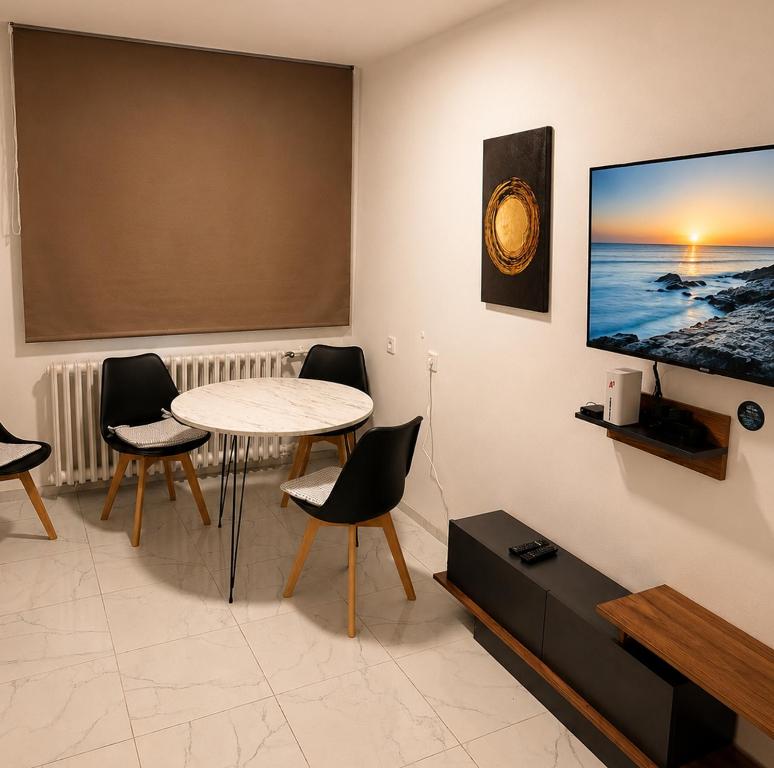 a living room with a table and a tv on a wall at Apartman City 2 With 2 Bedrooms and Free Parking in Negotin