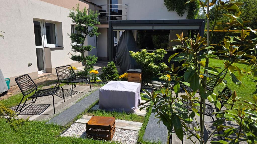 a garden with two chairs and a white box at Dom na Pięknej Ustroń in Ustroń