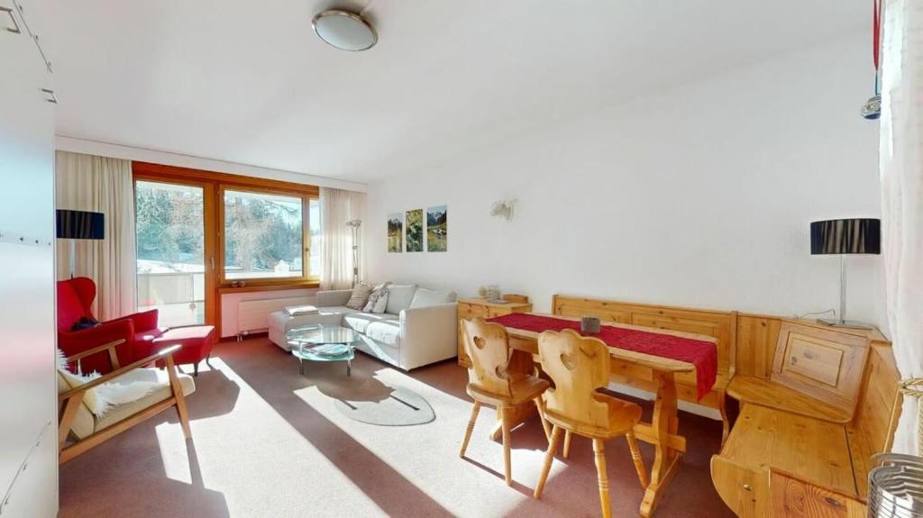 a living room with a table and chairs at Residenz Alpina im Kurhaus in Lenzerheide