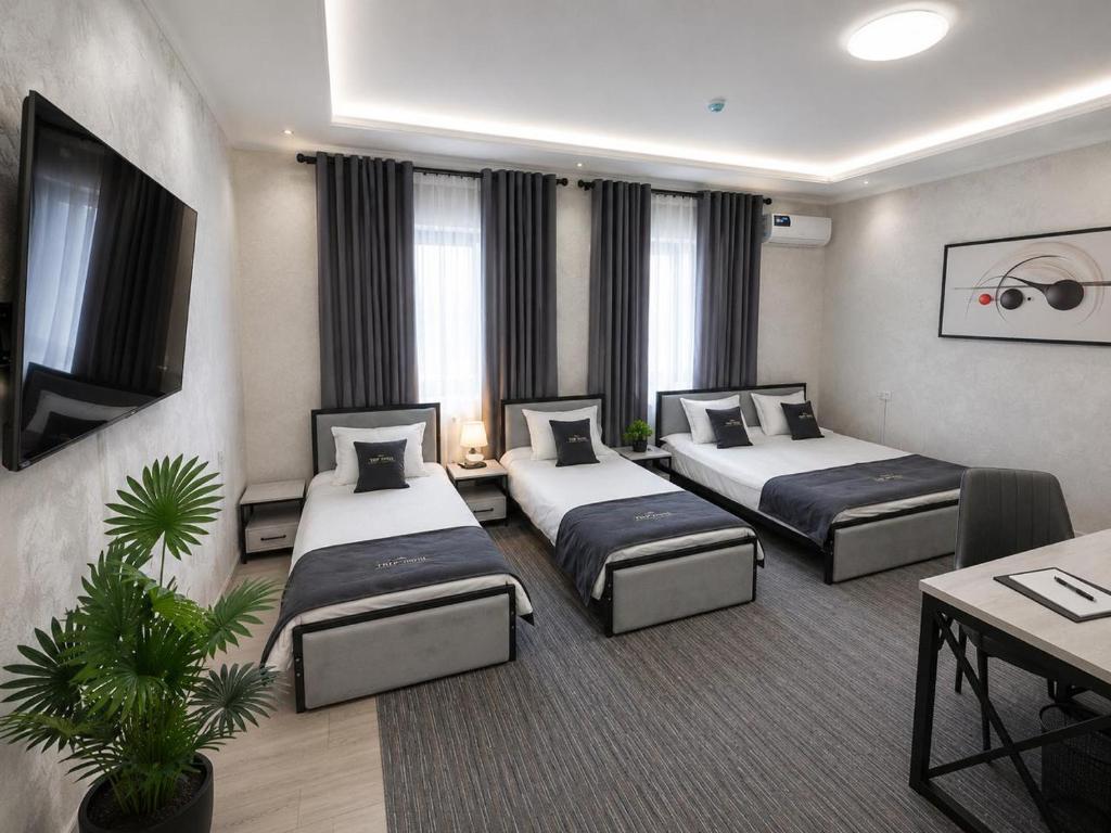 a hotel room with two beds and a table at TRIP Hotel in Toshkent-Passajir Bekati