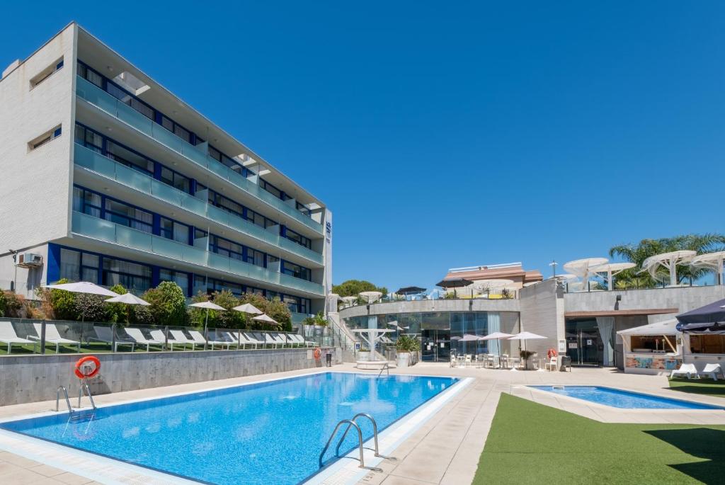 a swimming pool in front of a building at Apolo Suites Rentalmar in Salou