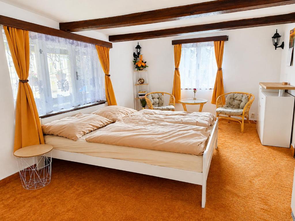 a bedroom with a bed and two chairs and a window at Apartmán Domeček u parku in Česká Lípa