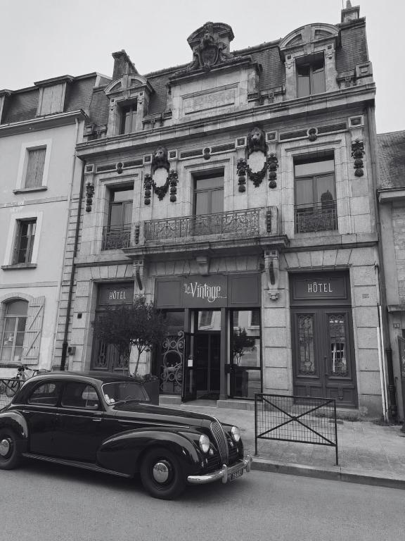 an old car parked in front of a building at Hôtel Vintage in Quimperlé