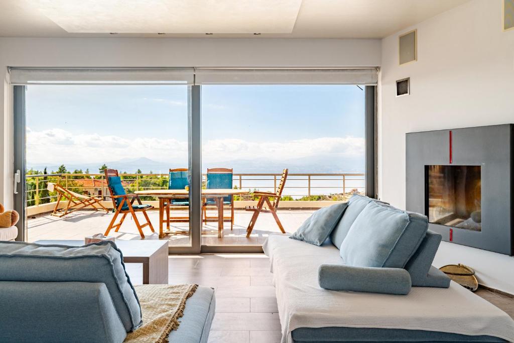 a living room with a couch and a fireplace at White Sand Loutraki Villa - Sea View in Loutraki
