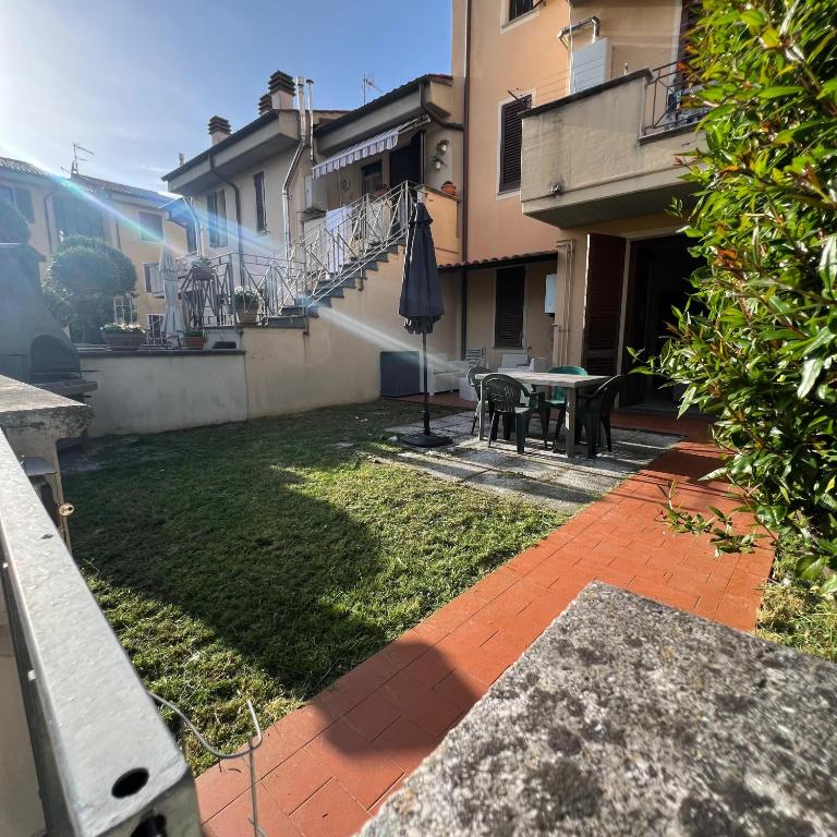 a patio with a table and an umbrella in a yard at Ponsy Dream - Firenze, Pisa, Livorno in Ponsacco