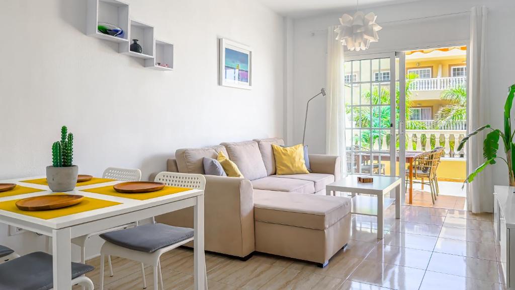 a living room with a couch and a table at Primavera apartment with heated pool in Palm-Mar