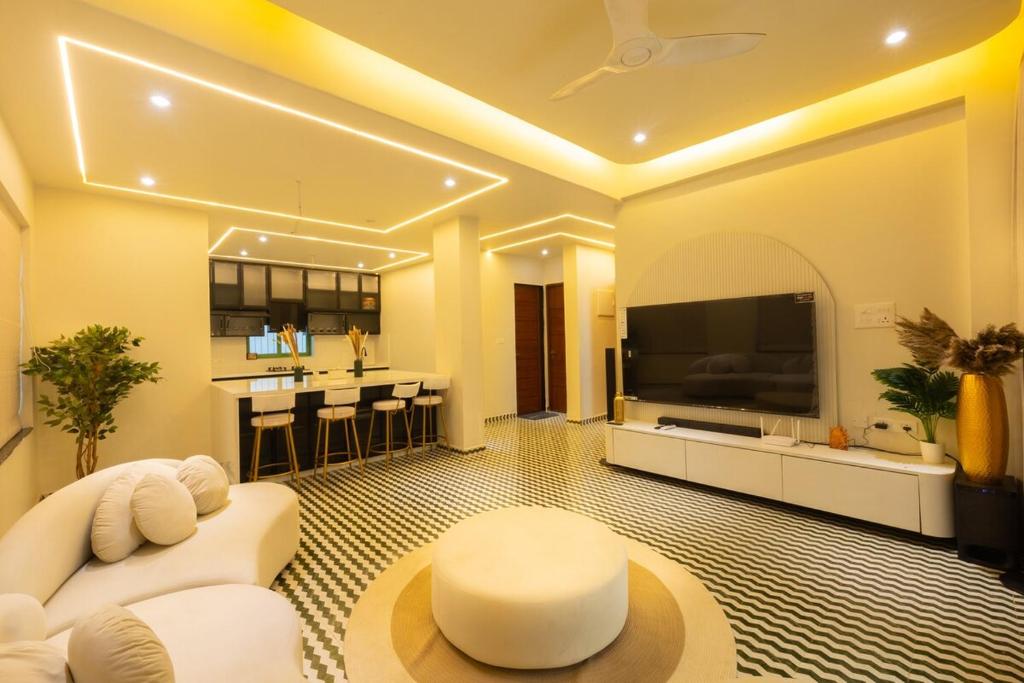 a living room with a white couch and a large tv at Luxury 3BHK Villa with Private Pool & PS5 in North in Socorro