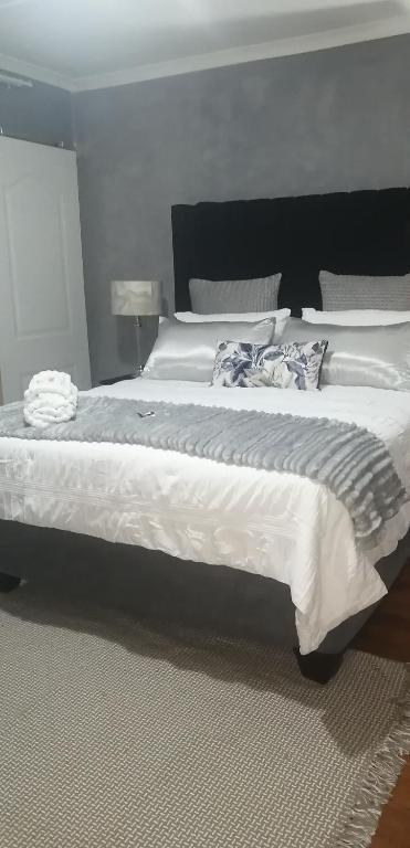 a bedroom with a large bed with white sheets at Radiant Residence in Grahamstown