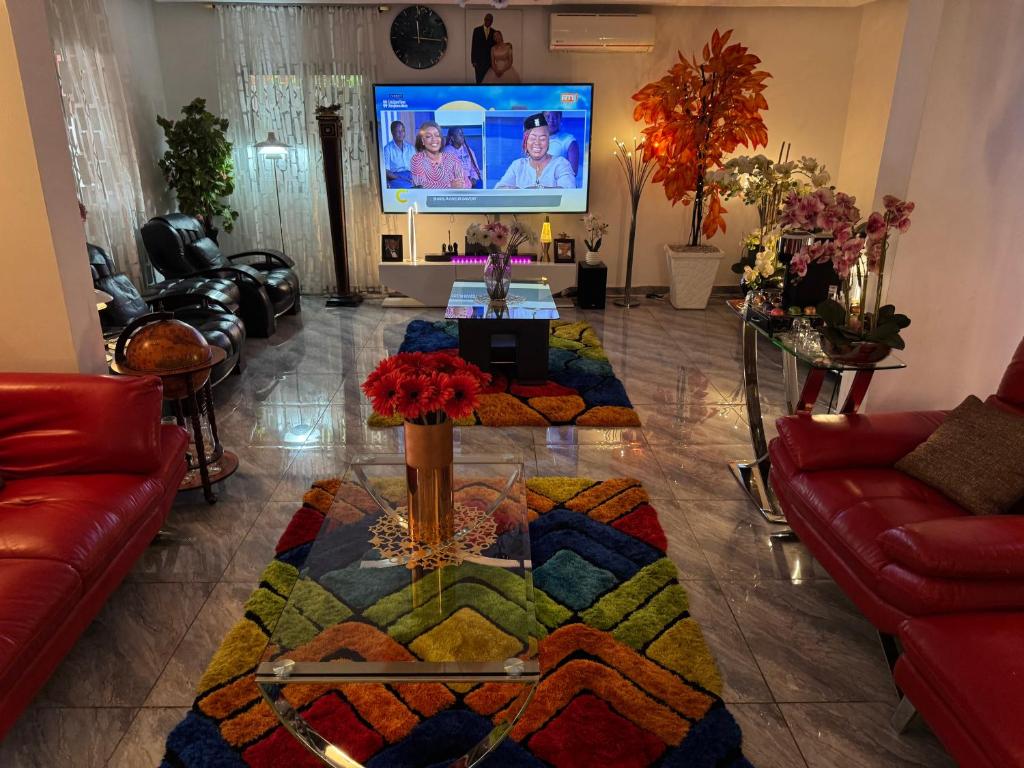 a living room with a couch and a tv at Noble Villa in Abidjan