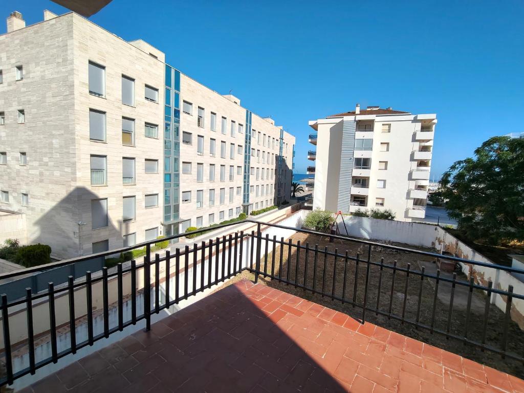 a balcony with a black fence and two buildings at Lamoga Ona in Torredembarra