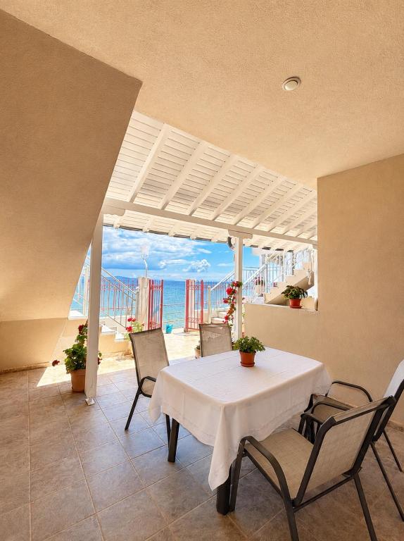 a dining room with a table and chairs and the beach at Val beach apartment in Nea Potidaea