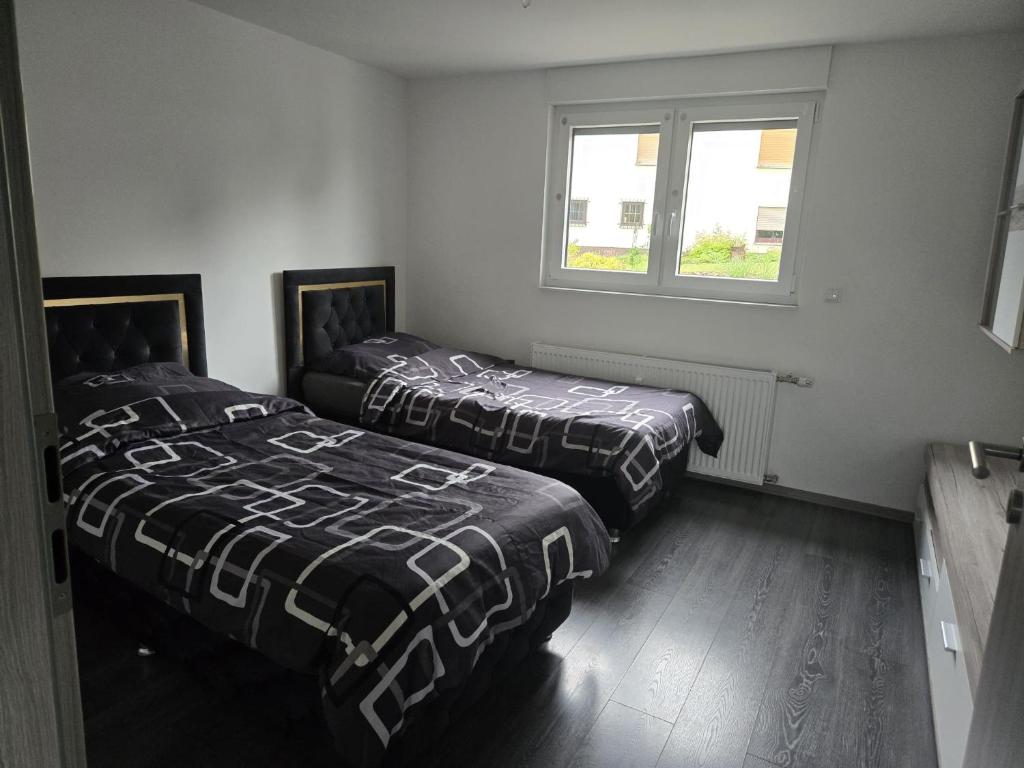 two beds sitting in a room with a window at RUHIGE Eke in Netphen