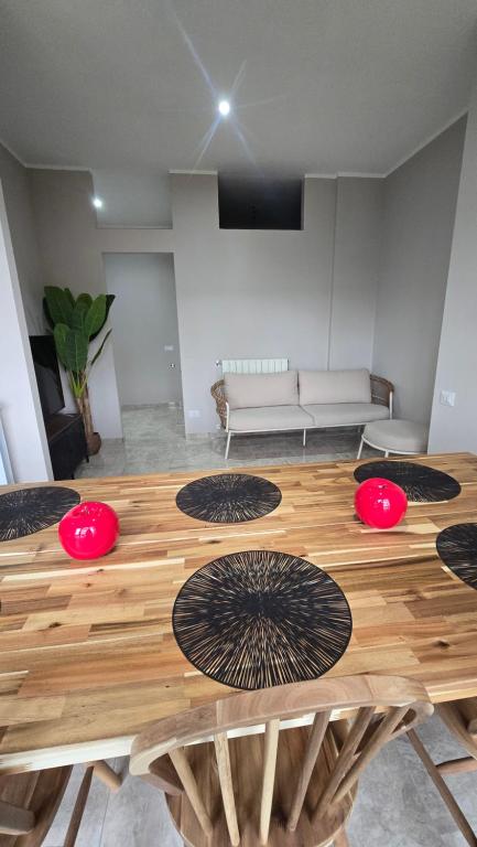 a living room with a wooden table with red chairs at B&B House Novara in Novara