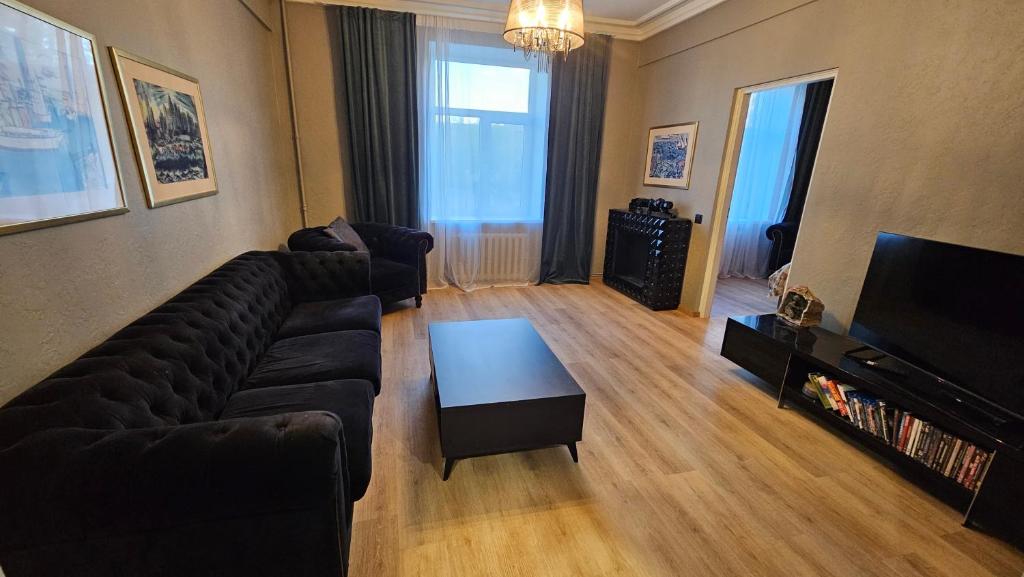 a living room with a couch and a television at Keskallee Charm in Kohtla-Järve
