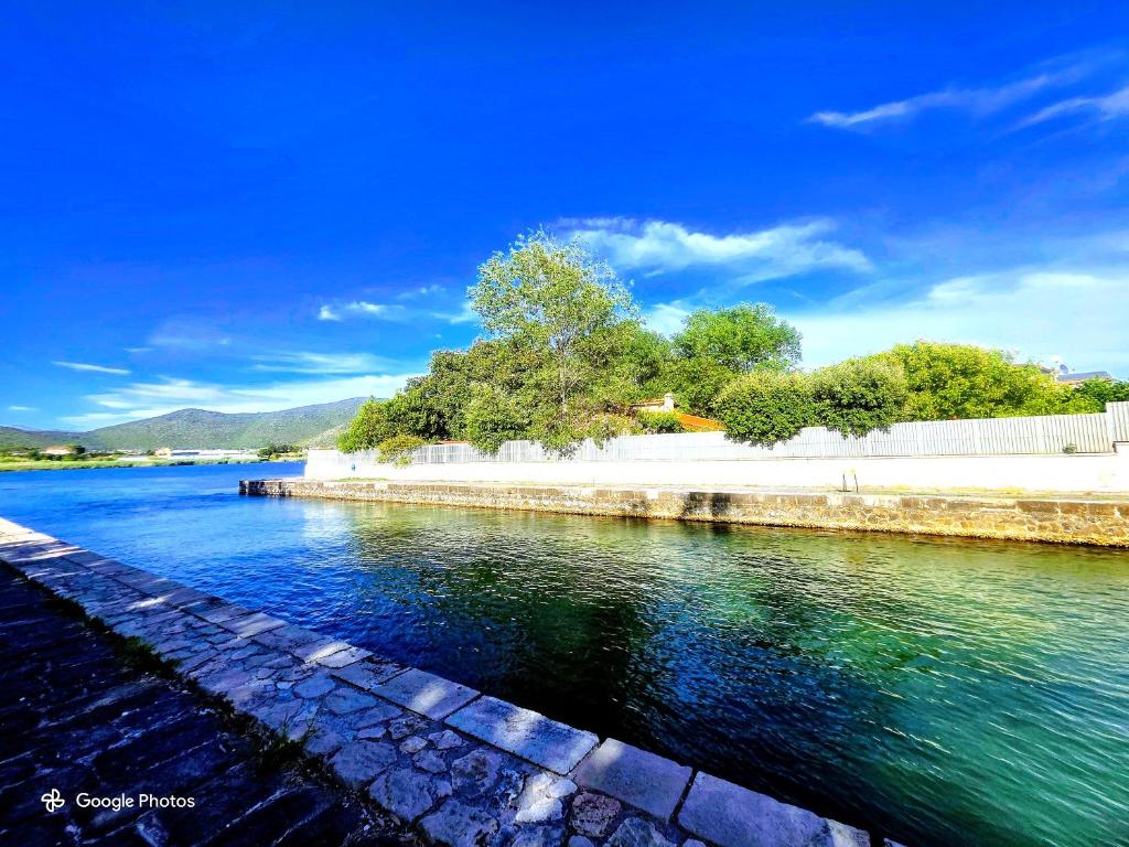 a body of water with trees and a fence at VILLA CECILIA sul LAGO fronte MARE in Sperlonga