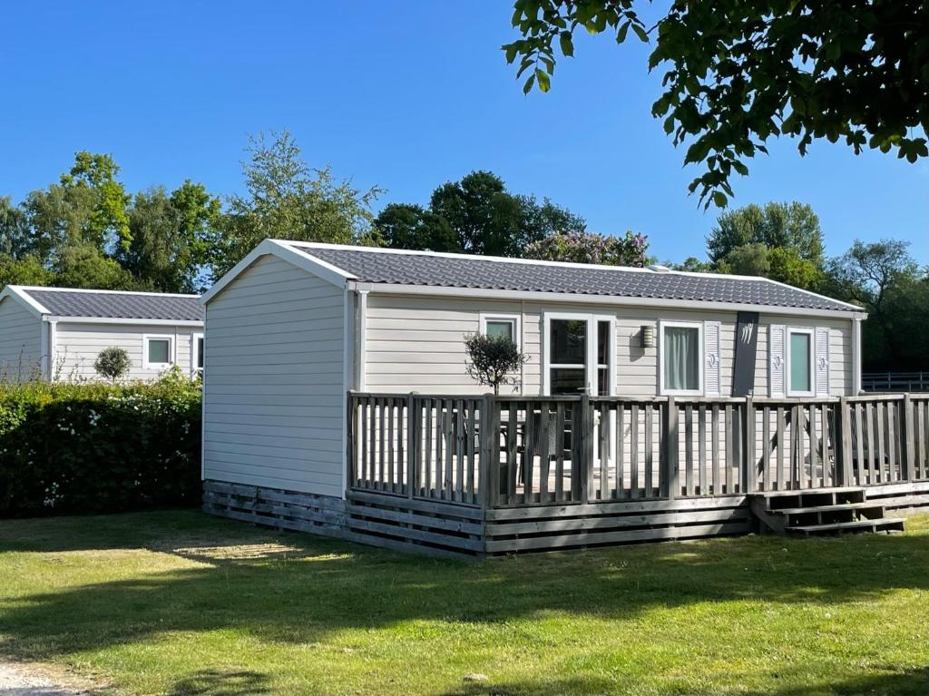 a small white house with a wooden fence at Gilleleje Camping in Gilleleje