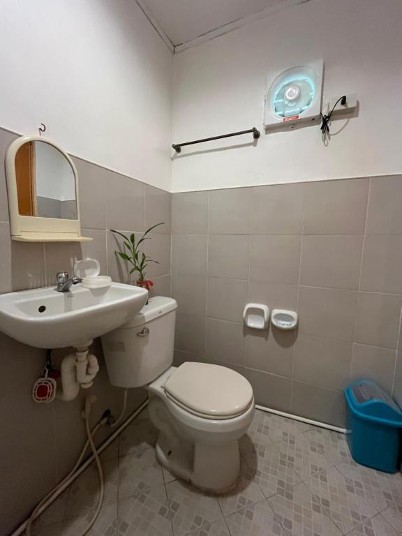 a bathroom with a white toilet and a sink at Ennas Place guest house in Coron
