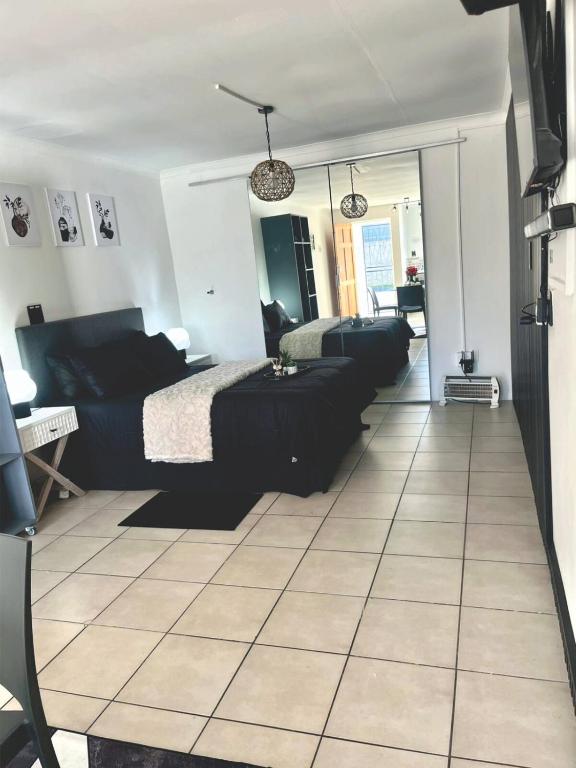 a bedroom with two beds and a tiled floor at Angel's Cottage Unit 2 in Paarl