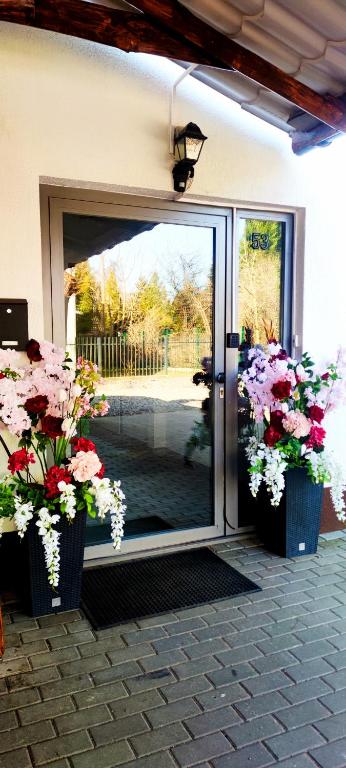 a glass door with two vases filled with flowers at ViLLA IVET in Gdańsk