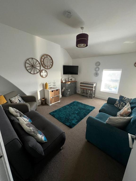 a living room with two couches and a television at Y Mor Cosy Apartment in Tywyn