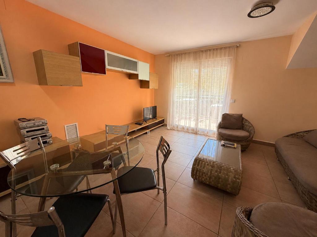 a living room with a glass table and a couch at Delfines III Solo Familias Serviplaya in Playa de Xeraco