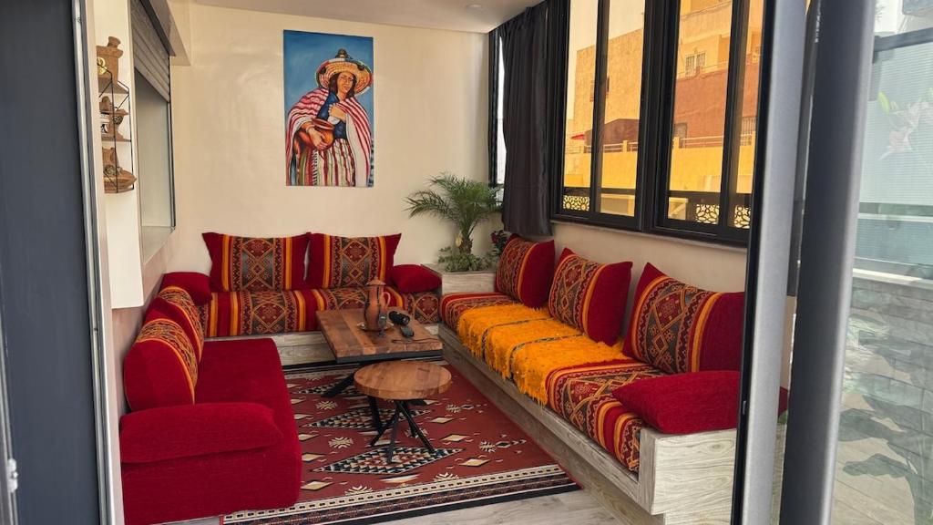 a living room with red couches and a table at Modern flat in a central location in Kenitra in Kenitra